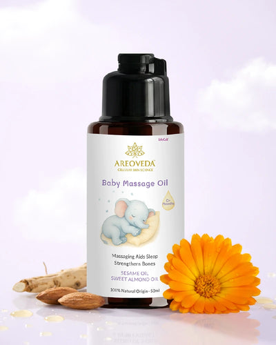 Baby massage oil bottle with a white label featuring an elephant illustration, surrounded by almonds and a marigold flower on a light purple background.