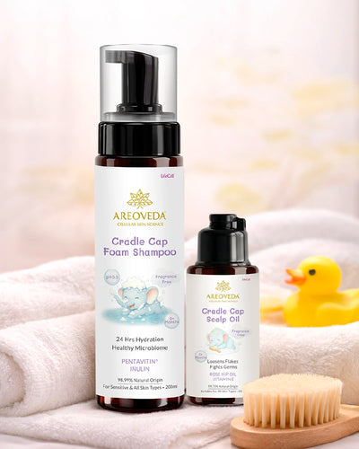Two bottles of AreoVeda Cradle Cap products on a towel with a rubber duck and brush in the background.